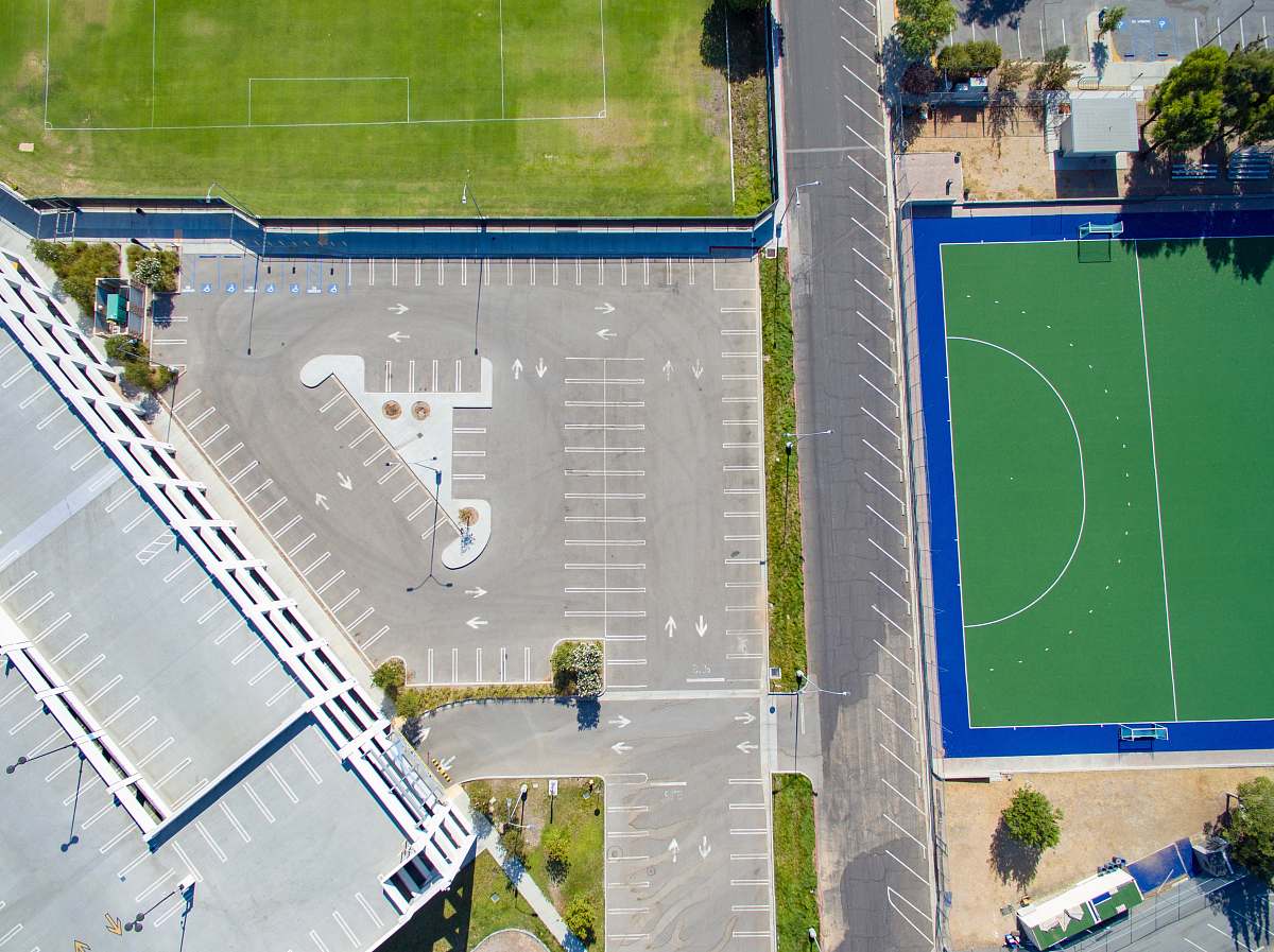 team sport aerial photo of gray concrete pavements near field and tress basketball court
